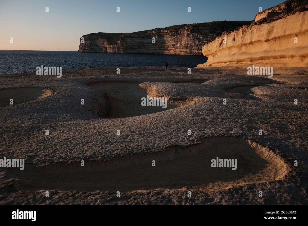 Xlendis Salzpfannen bei Sonnenuntergang neben dem Turm von Xlendi. Stockfoto