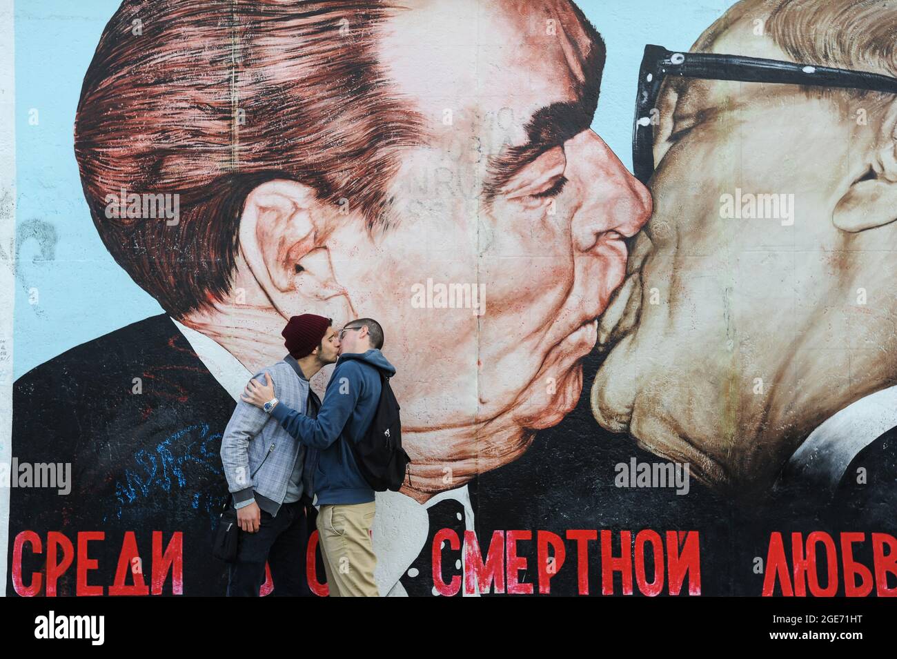 22.09.2014, Berlin, Deutschland, Europa - zwei junge Männer küssen sich vor dem berühmten Wandgemälde an der Berliner Mauer in der East Side Gallery in Friedrichshain. Stockfoto