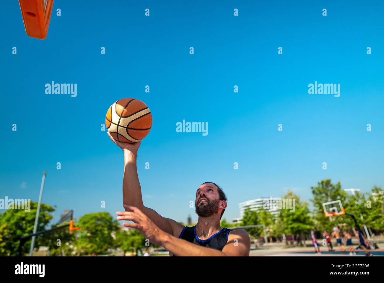 Die Hand des Sportlers, der Basketball spielt, wirft den Ball auf den Spielplatz, macht Hook Schuss von Jump Shot, Blick von hinten. Präzisionsschuss Stockfoto
