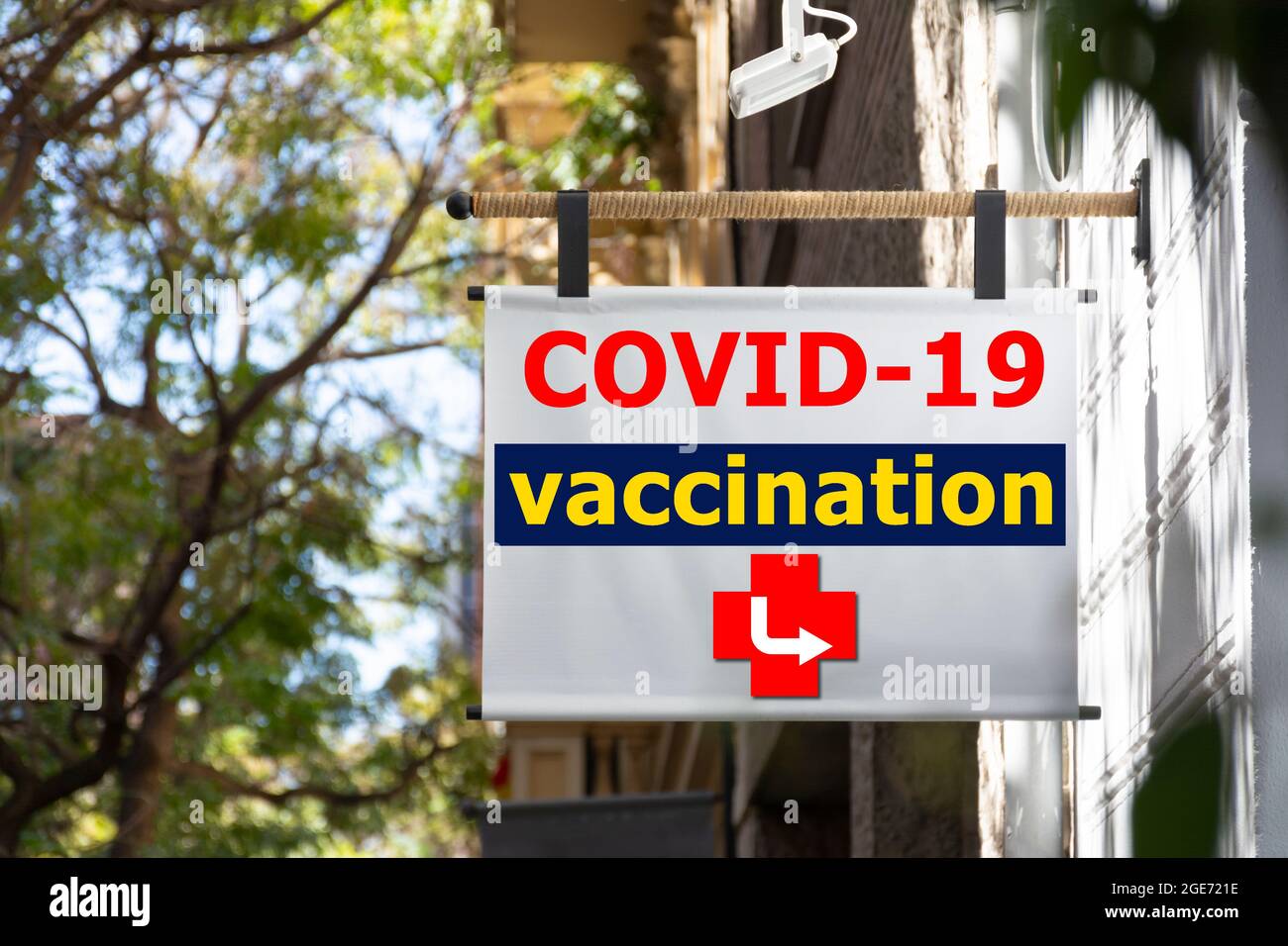 Hängeschild auf der Straße mit digitalem Text, der über den Impfpunkt covid 19 informiert, mit einem Indikatorpfeil Stockfoto