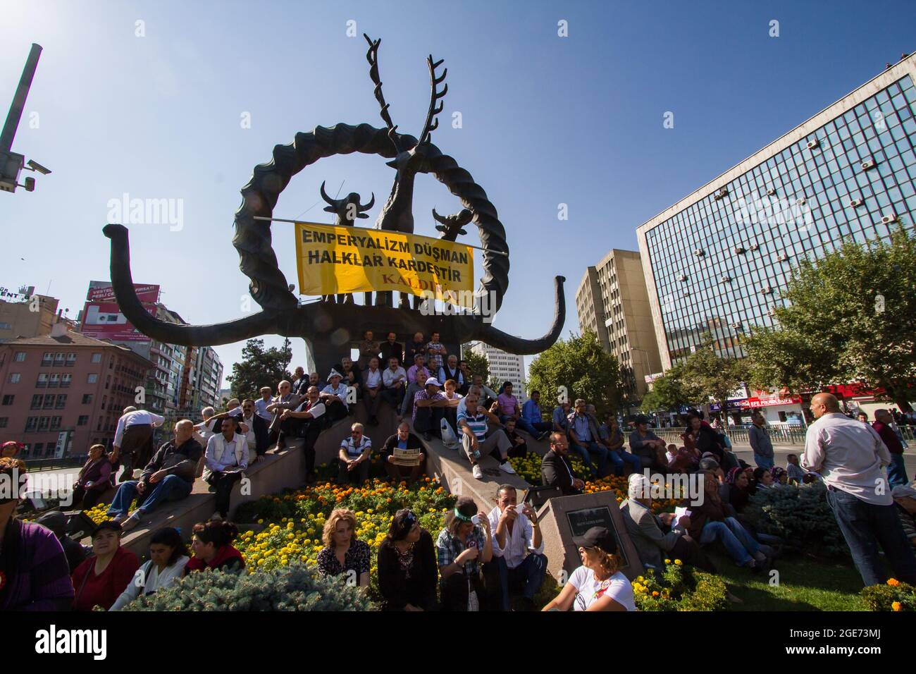 Während der Alevis-Demonstration gegen Diskriminierung und gegen die Beteiligung der Türkei am Krieg in Syrien wird ein Banner mit der Aufschrift "Imperialismus ist der Feind - Völker sind Brüder" über dem ikonischen Hattiandenkmal auf dem Sıhhıye-Platz aufgehängt. Stockfoto