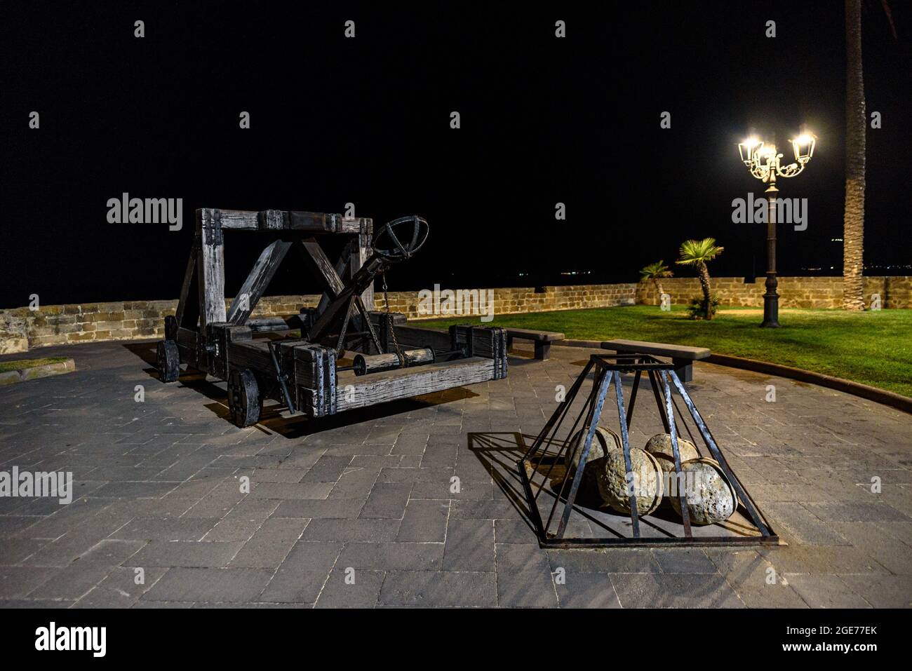 Ein Katapult auf der Stadtmauer von Alghero in der Nacht Stockfoto