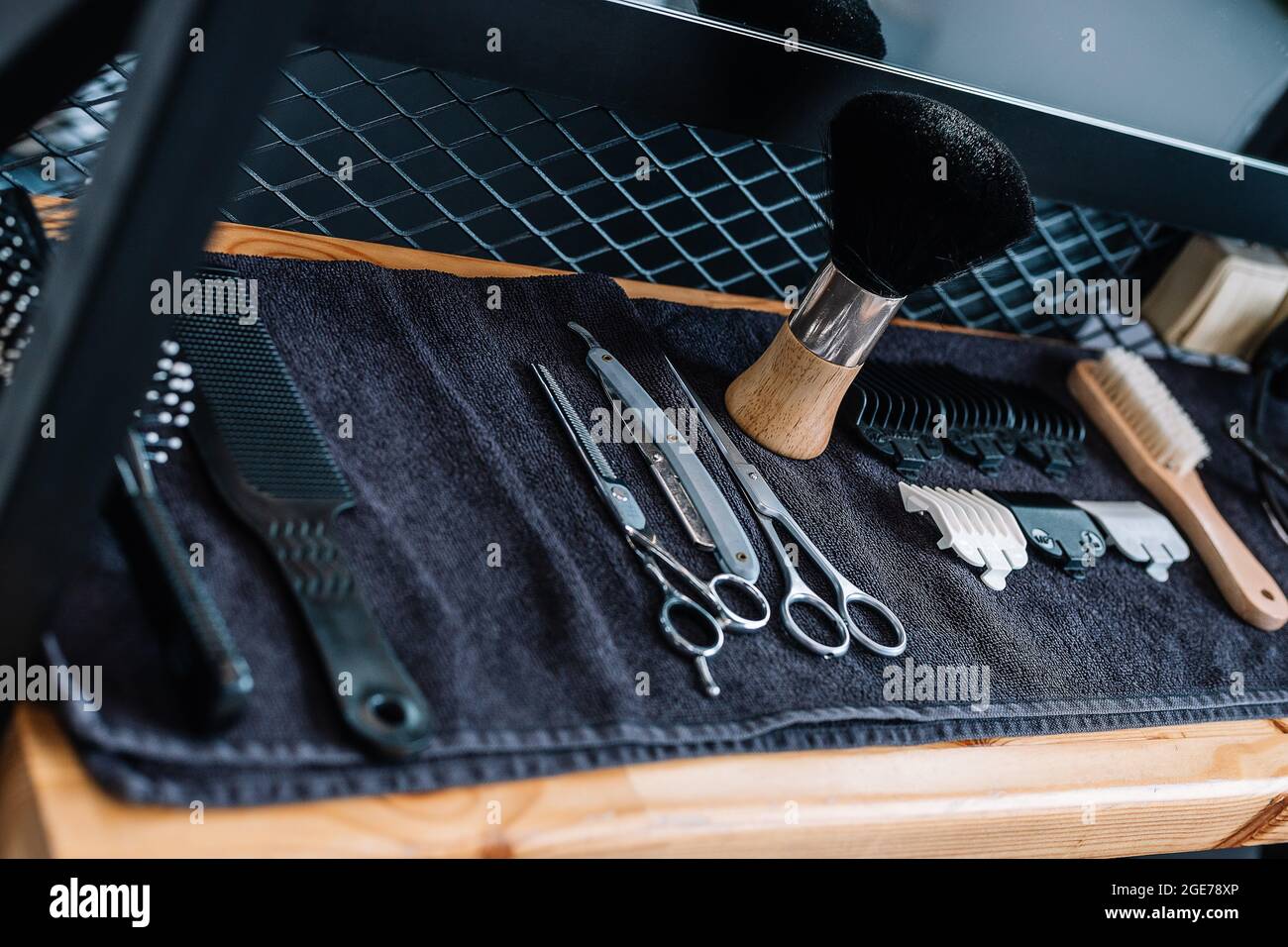 Professionelle Barbier Werkzeuge und Ausrüstung. Nahaufnahme Rasierpinsel, Rasiermesser, Schere, Kämme auf dem Tisch auf einem schwarzen Handtuch. Barbershop. Professionelle Herren s Stockfoto