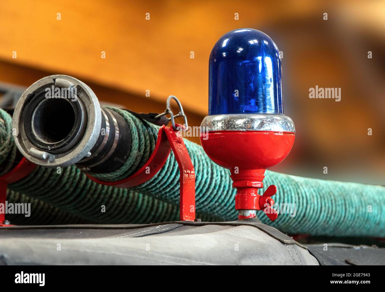 Nahaufnahme eines blauen Lichts und eines Löschschlauchs auf dem Dach eines antiken Feuerwehrmotors Stockfoto