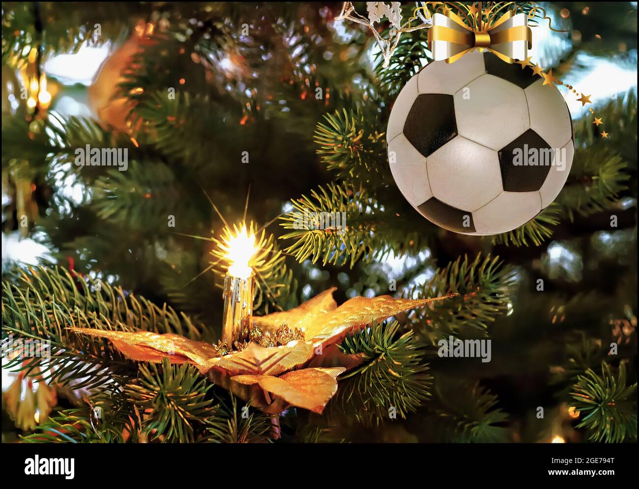Fußball-weihnachtskugel, die auf dem Tannenzweig hängt. Weihnachtsgrüße Stockfoto