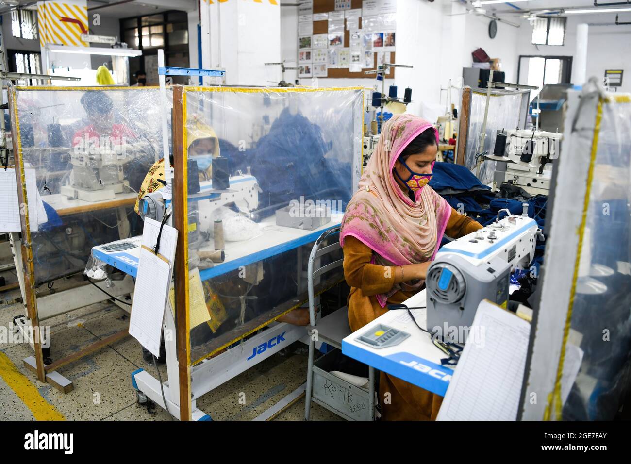 Dhaka, Bangladesch. August 2021. Mitarbeiter von Ready-Made Garment (RMG) arbeiten in der Bekleidungsfabrik Civil Engineering Limited in Dhaka getrennt durch Polyethylenfolien als Sicherheitsmaßnahme zur Reduzierung der Ausbreitung des Coronavirus. Kredit: SOPA Images Limited/Alamy Live Nachrichten Stockfoto