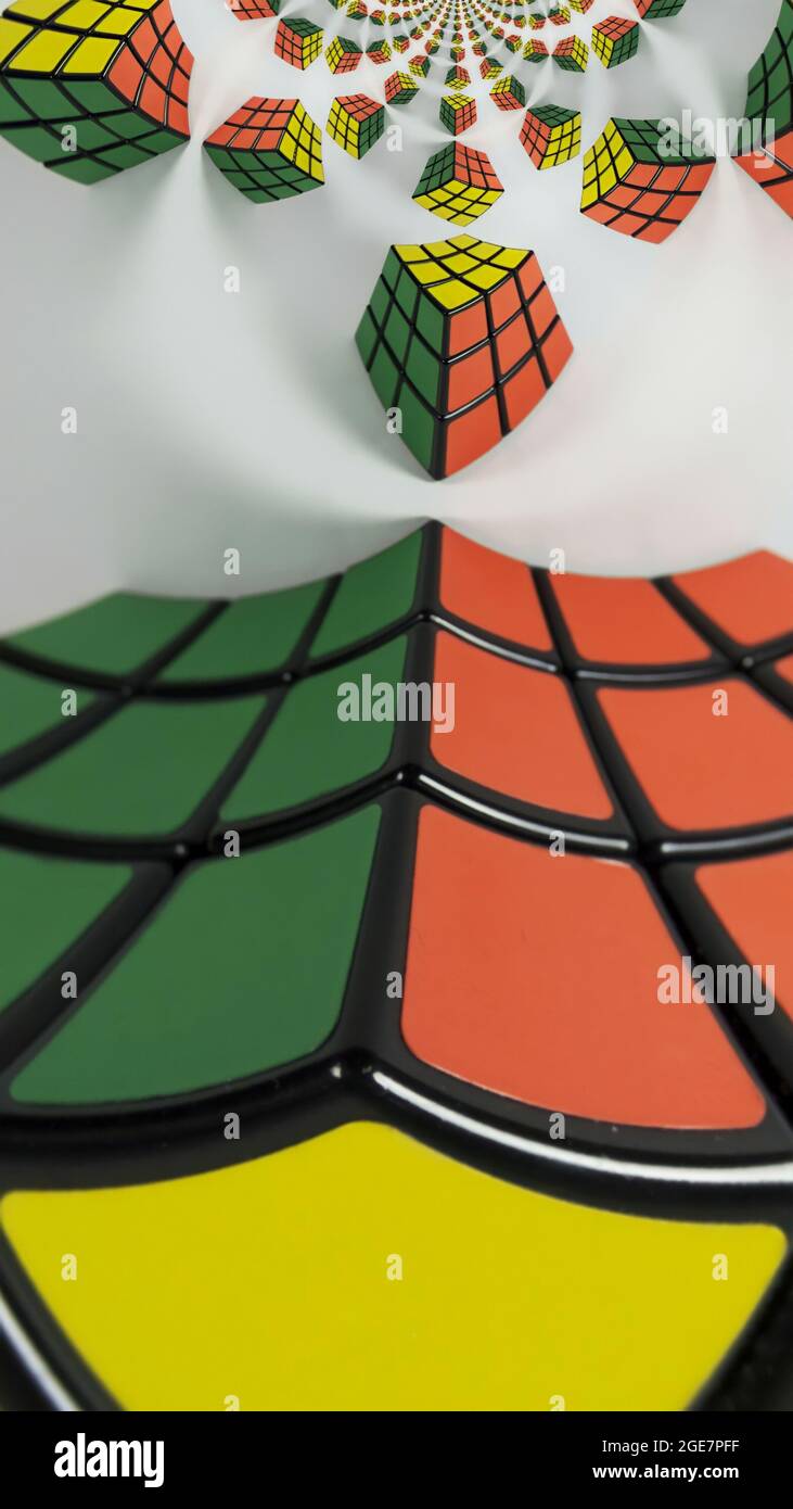 Vertikale Aufnahme eines bunten Puzzlewürfels, der mit abstrakten Formen an der Decke gespiegelt ist Stockfoto