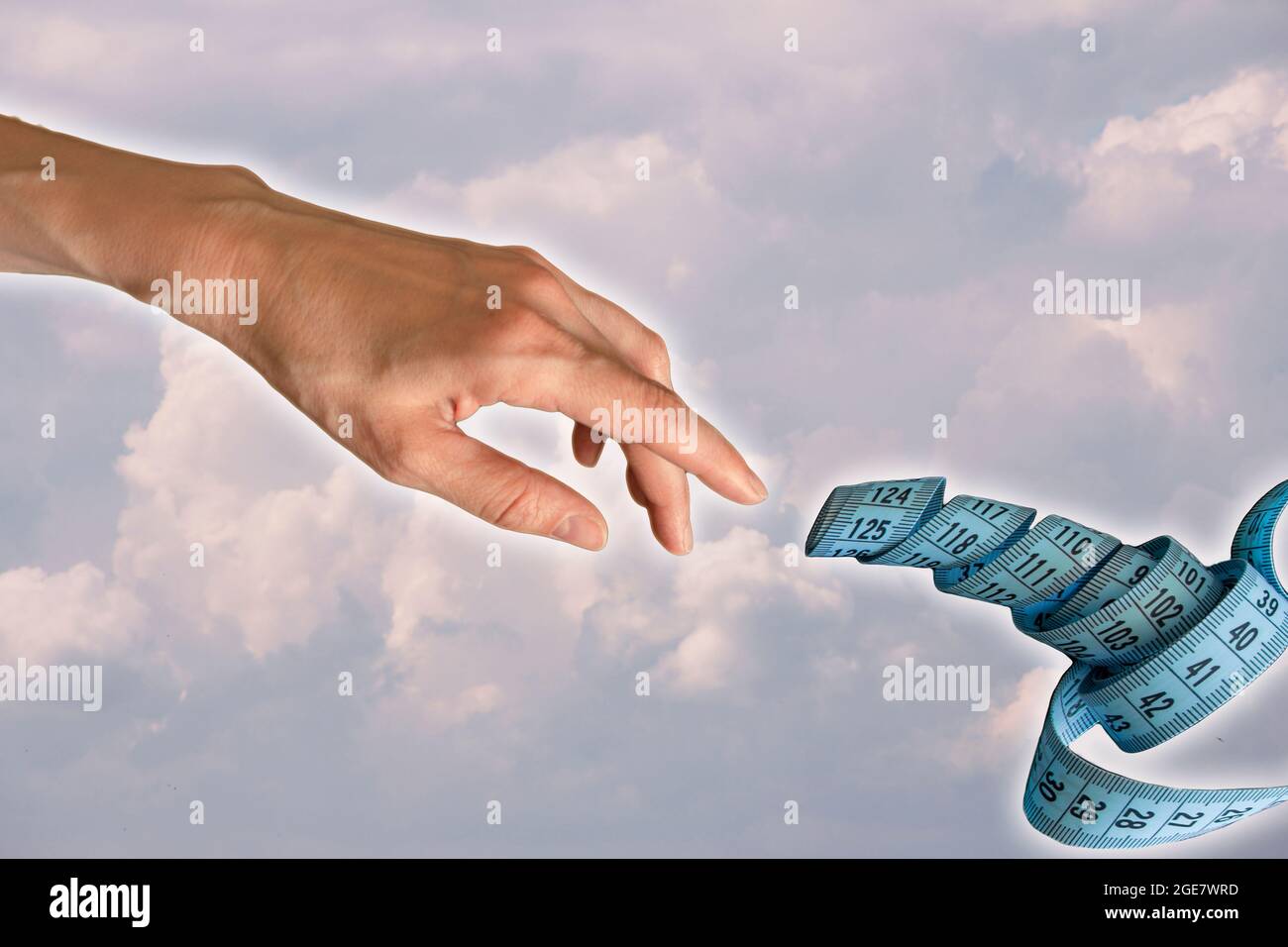Eine Frauenhand ist ausgestreckt, um ein blaues Maßband auf dem Hintergrund des Wolkenhimmels zu berühren, basierend auf dem Gemälde The Creation of Adam von Michelangelo Stockfoto