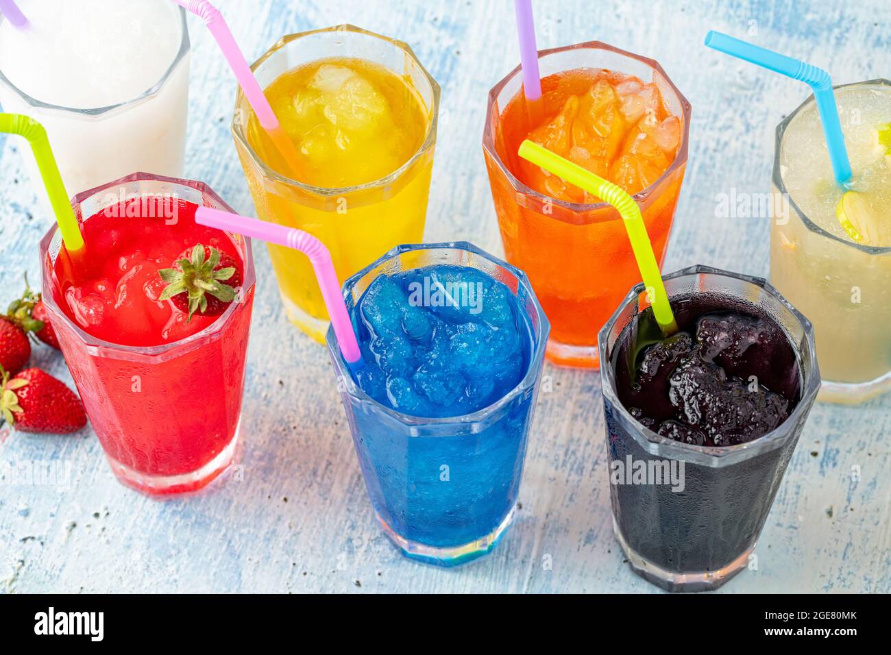 Erfrischende Frozen in verschiedenen Früchten und Farben auf blauem Hintergrund. Stockfoto