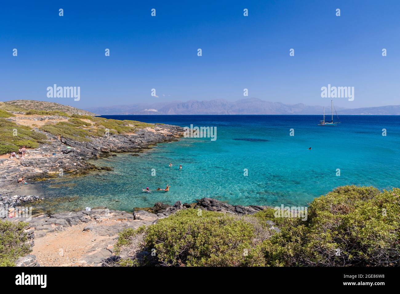 ELOUNDA, KRETA - 11. JULI 2021: Klares Wasser und trockenes Gestrüpp an der Küste in der Nähe der Stadt Elounda, Kreta, Griechenland Stockfoto