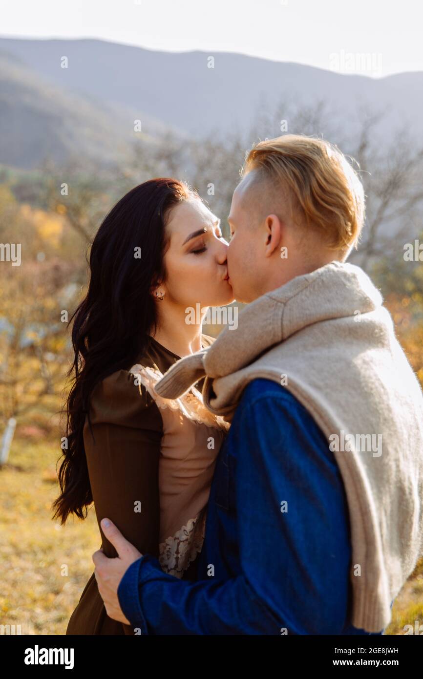 Junges Paar küsst sich auf dem Hintergrund von Wald und Bergen. Stockfoto