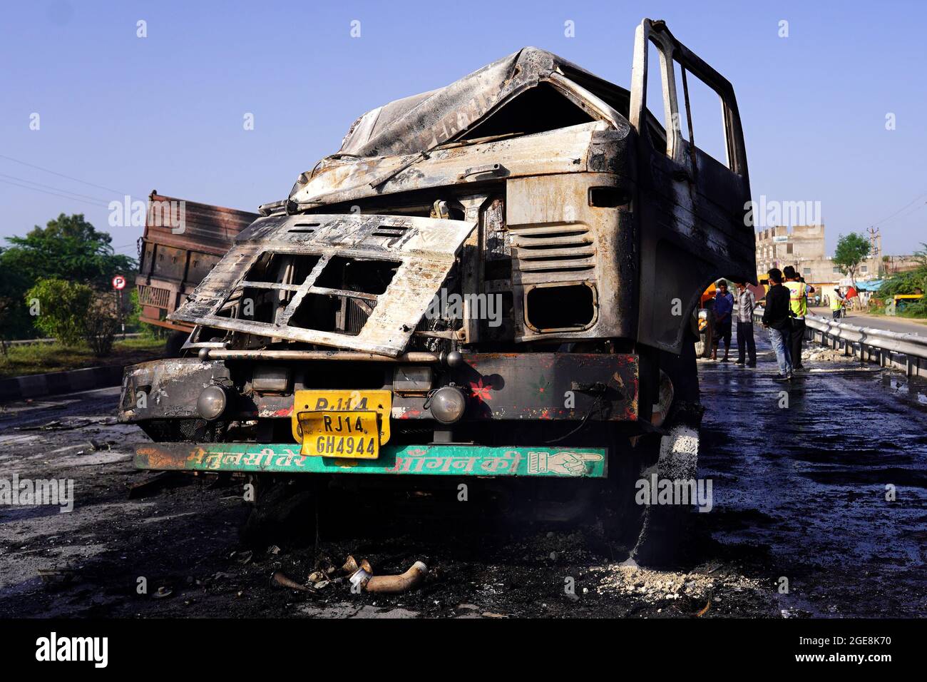 Nicht exklusiv: Ein Arbeiter wird gesehen, wie er den LKW überprüft, der nach dem Unfall beschädigt wurde. Ein Feuer bricht aus nach einer Kollision zwischen zwei LKWs auf einem Nat Stockfoto