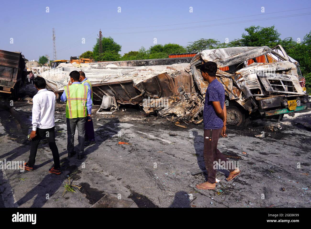 Nicht exklusiv: Ein Arbeiter wird gesehen, wie er den LKW überprüft, der nach dem Unfall beschädigt wurde. Ein Feuer bricht aus nach einer Kollision zwischen zwei LKWs auf einem Nat Stockfoto