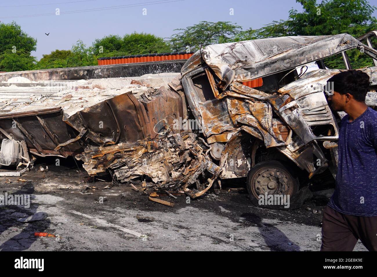 Nicht exklusiv: Ein Arbeiter wird gesehen, wie er den LKW überprüft, der nach dem Unfall beschädigt wurde. Ein Feuer bricht aus nach einer Kollision zwischen zwei LKWs auf einem Nat Stockfoto
