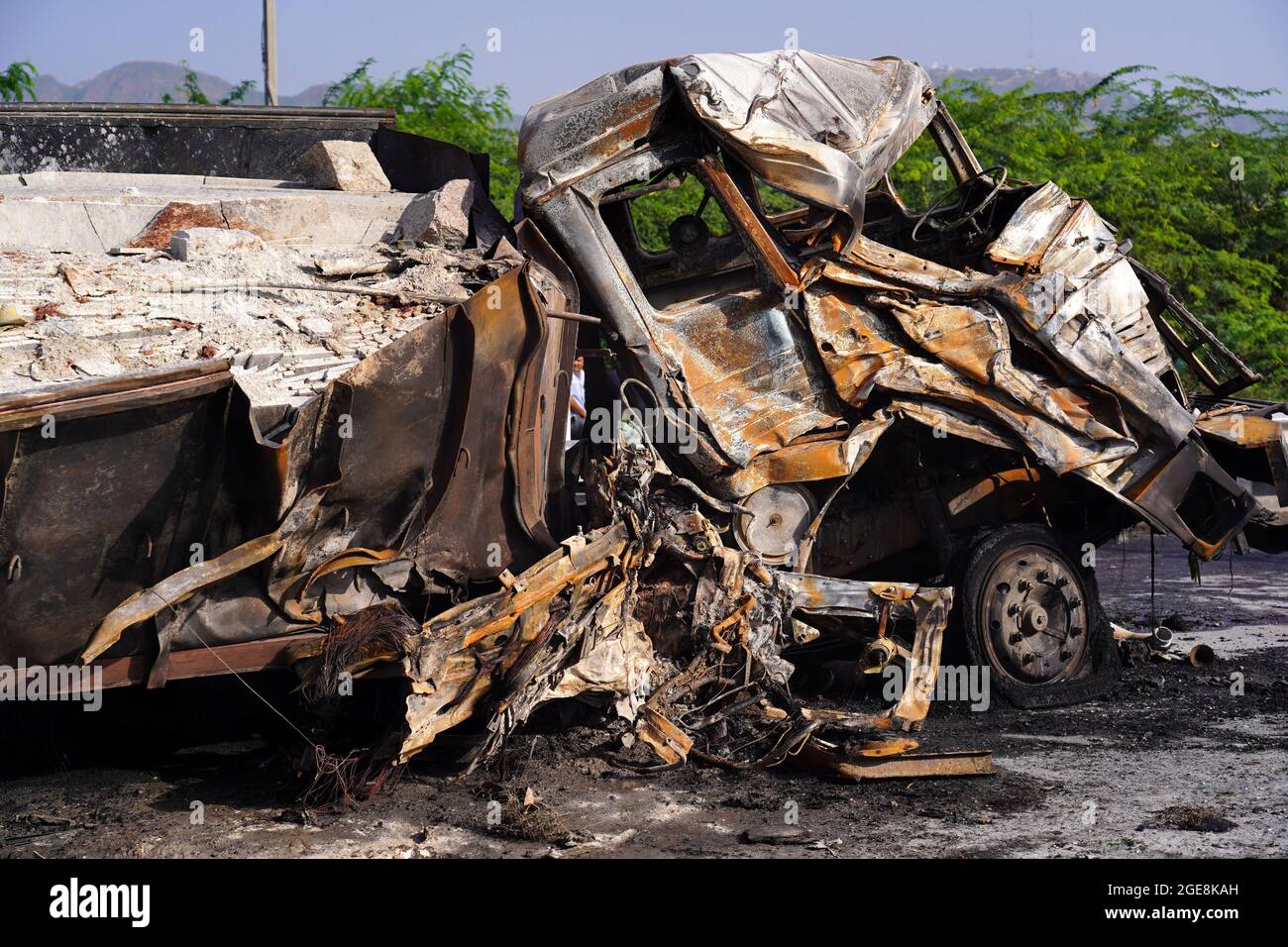 Nicht exklusiv: Ein Arbeiter wird gesehen, wie er den LKW überprüft, der nach dem Unfall beschädigt wurde. Ein Feuer bricht aus nach einer Kollision zwischen zwei LKWs auf einem Nat Stockfoto