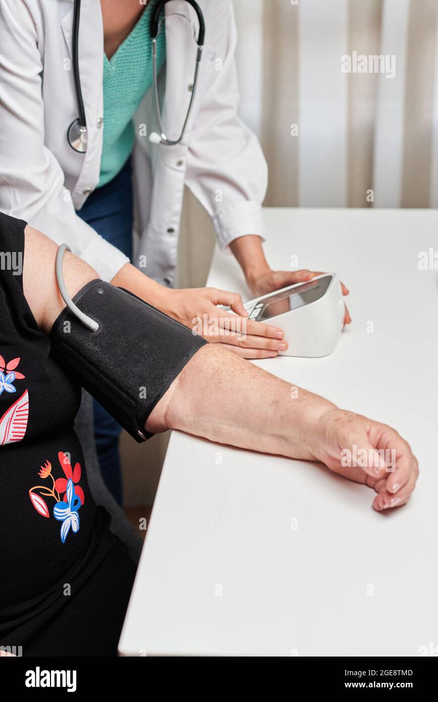 Eine Ärztin misst den Blutdruck eines Patienten Stockfoto