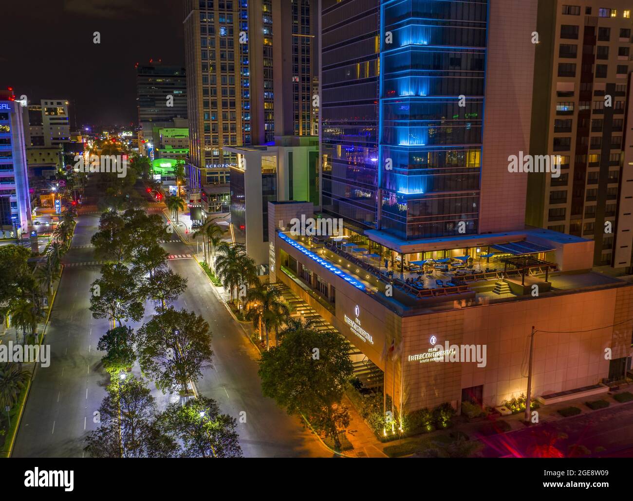 Moderne Gebäude umgeben von Lichtern am Abend in San Juan de la Maguana Stockfoto