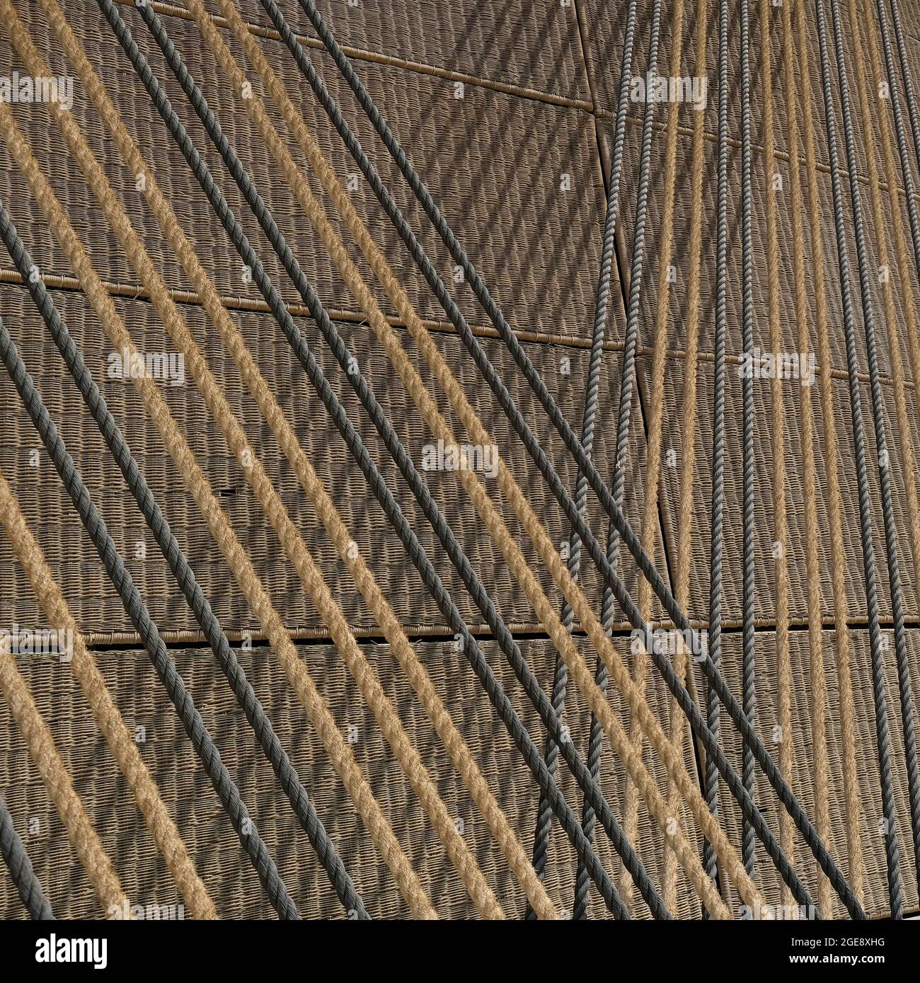 Eco Hintergrund.Crossing schräg straff gestreckte Jute Haltbarkeit Seile über strukturierte biologisch abbaubare geflochtene Korbmatten. Dekorative Naturwand. Stockfoto