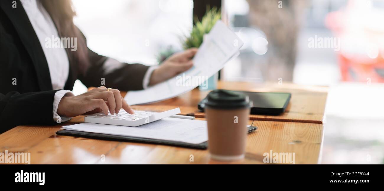 Buchhalter, der am Schreibtisch arbeitet und einen Rechner für die Berechnung des Finanzberichts im Café verwendet. Stockfoto