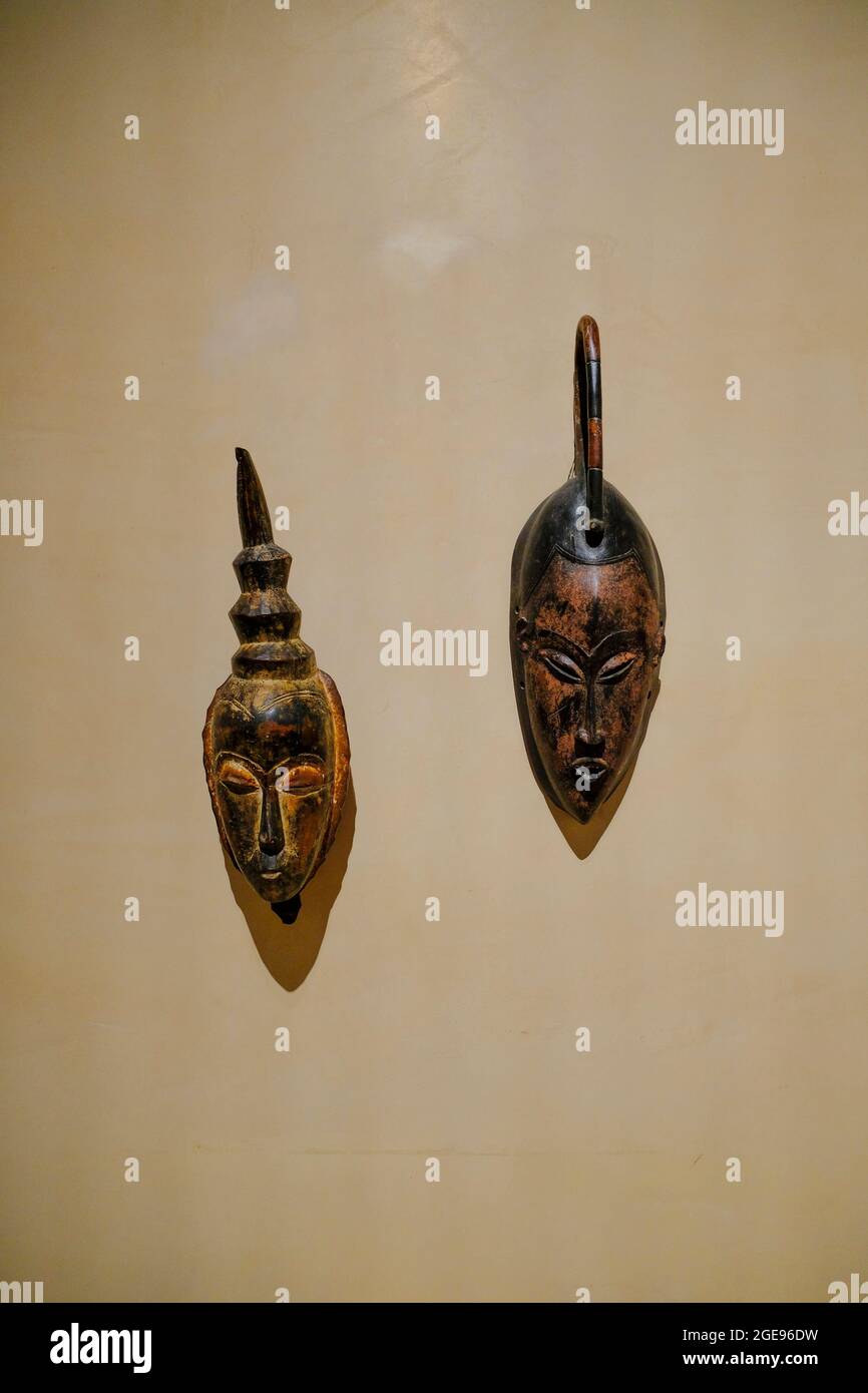 Parma, Italien: Zwei afrikanische Holzmasken auf weißer Wand aus der Nähe im Museum Magnani Rocca Stockfoto