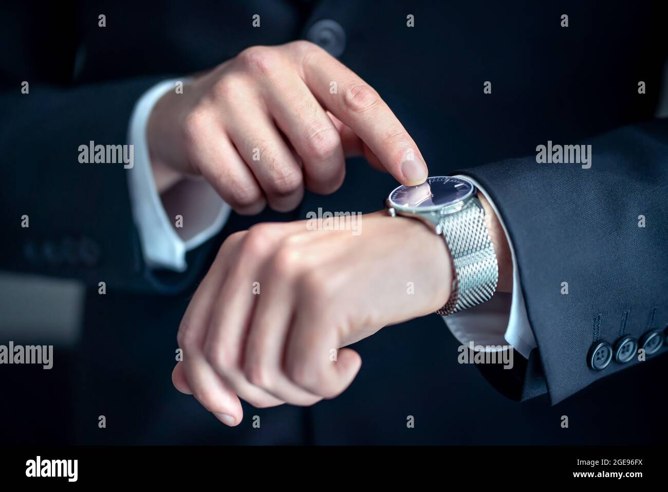 Sehen Sie sich das Handgelenk eines eleganten Geschäftsmanns an. Beschäftigter Geschäftsmann, der die Zeit betrachtet. Stress oder Eile bei der Arbeit. Person, die Anzug trägt. Stockfoto