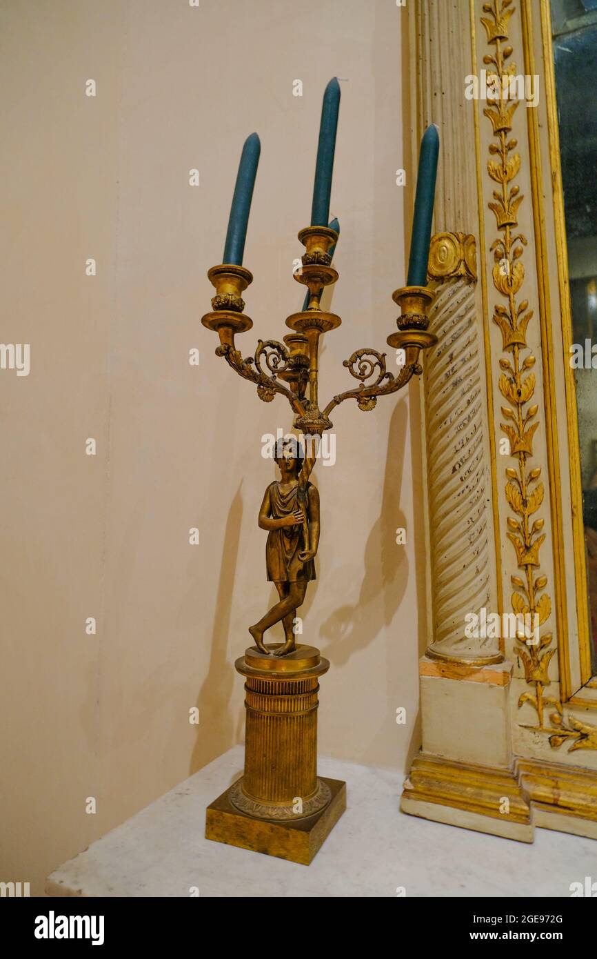 Schöne antike goldene Kerzenständer Nahaufnahme mit blauen Kerzen über Bilderrahmen und Wand. Inneneinrichtung Stockfoto