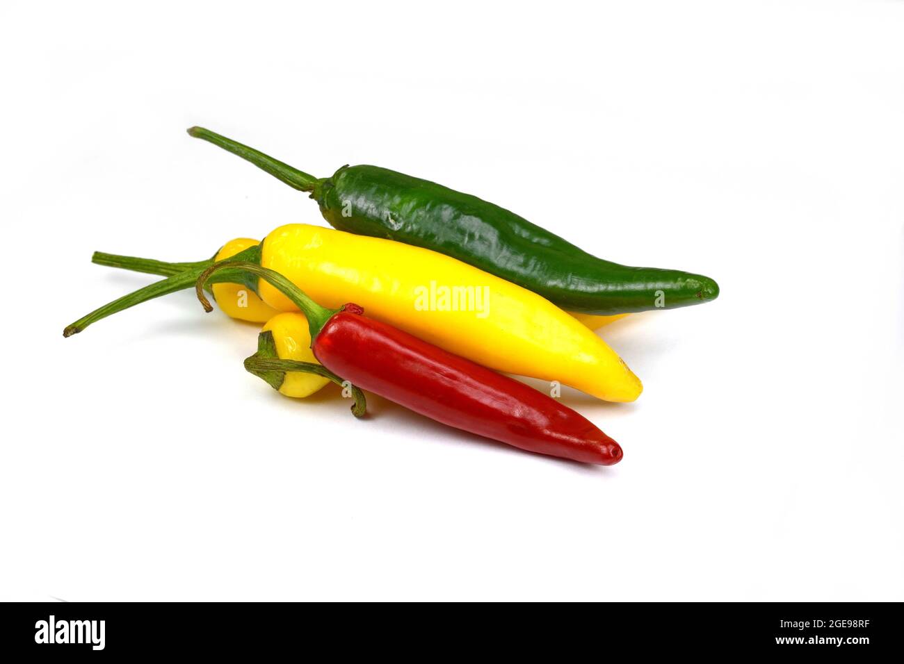 Chiili-Paprika in verschiedenen Farben, gelb, grün und rot, isoliert auf weiß; auch bekannt als Chilischoten, chilli-Paprika oder einfach nur Chili Stockfoto