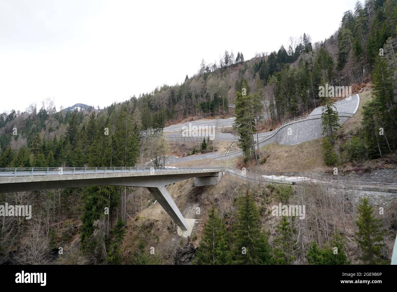 Serpentinenstraße auf einem Berghang in der Region Versam in der Schweiz. Es gibt auch eine Brücke über den Fluss Rabiusa. Stockfoto