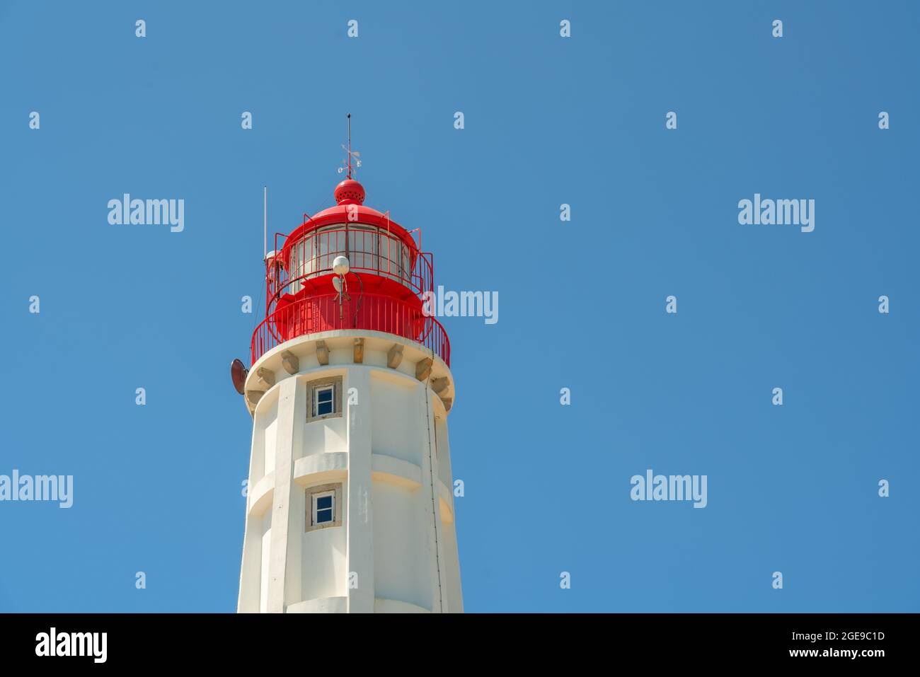 Ein weißer Leuchtturm mit einer roten Spitze, gegen den blauen Himmel. Ein konzeptionelles Signal für die Richtung von allem. Speicherplatz kopieren Stockfoto