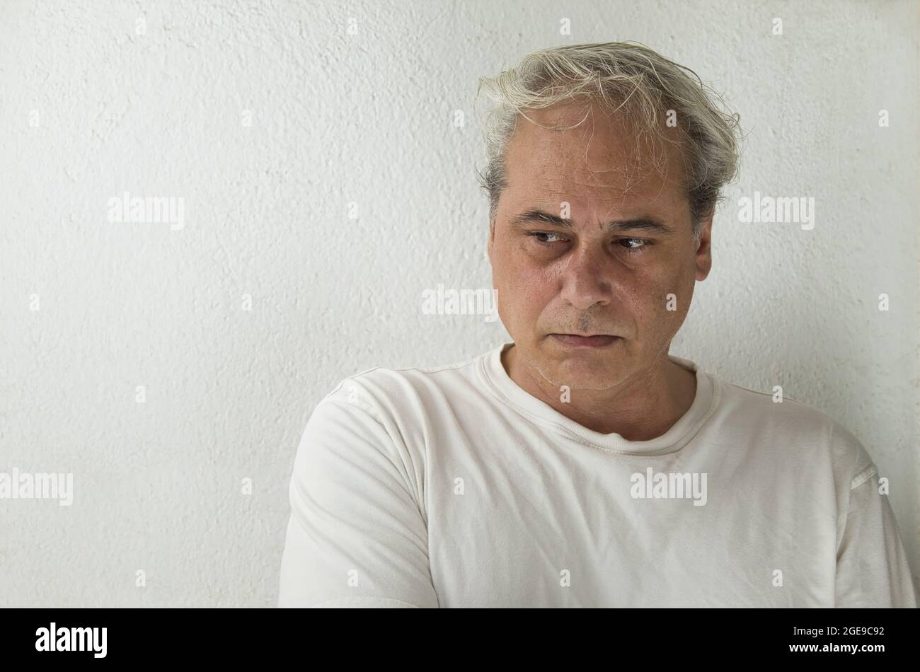 Porträt eines reifen Mannes mit grauen Haaren in weißem Hemd auf weißem Hintergrund Stockfoto
