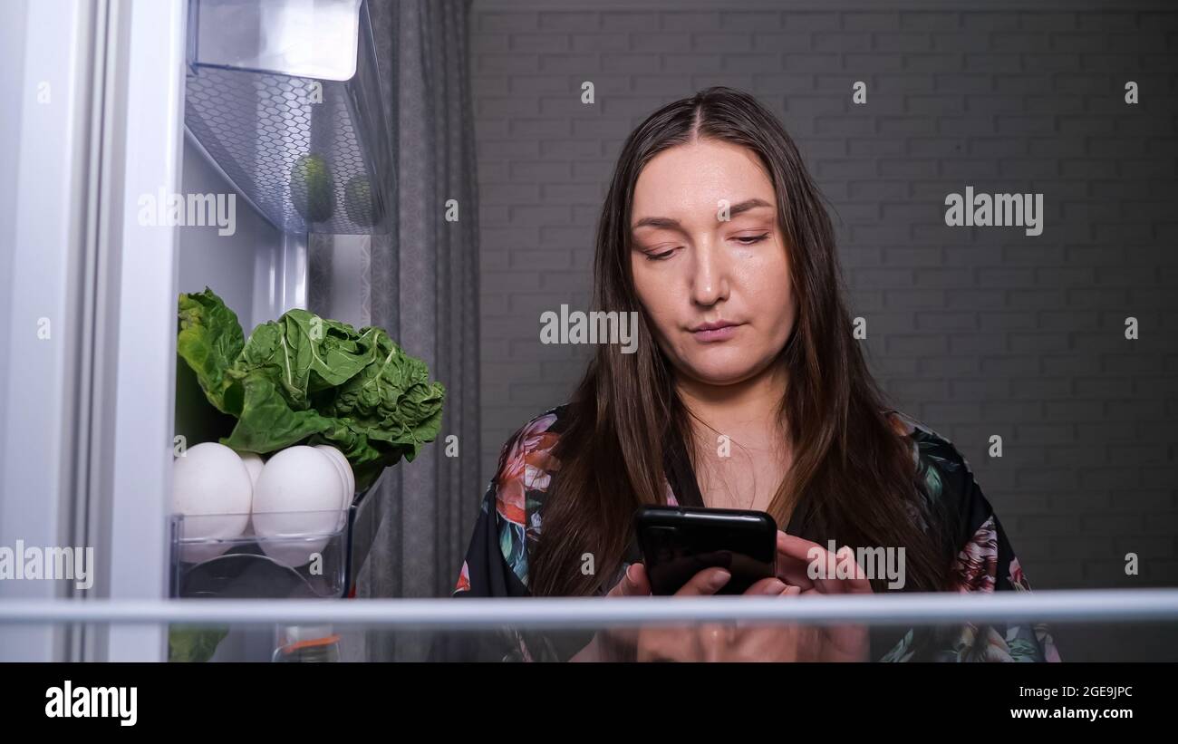 Konzentrierte Frau macht Liste der Lebensmittel zu kaufen Stockfoto