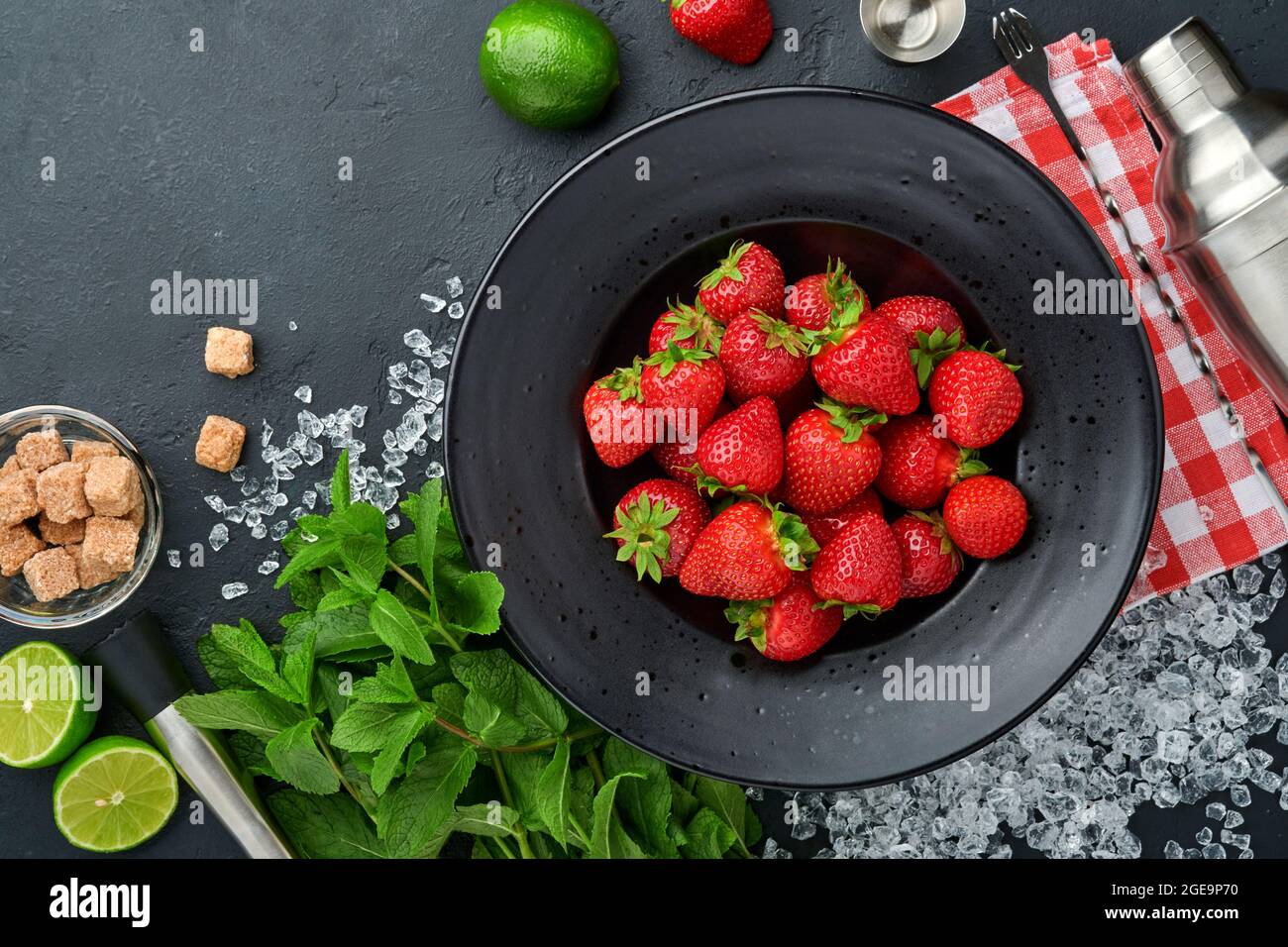 Lebensmittel Frische Zutaten für die Herstellung von Limonade, infundiert entgiftendes Wasser oder Cocktail. Erdbeeren, Limette, Minze, Basilikum, Rohrzucker, Eiswürfel und Shaker auf bla Stockfoto