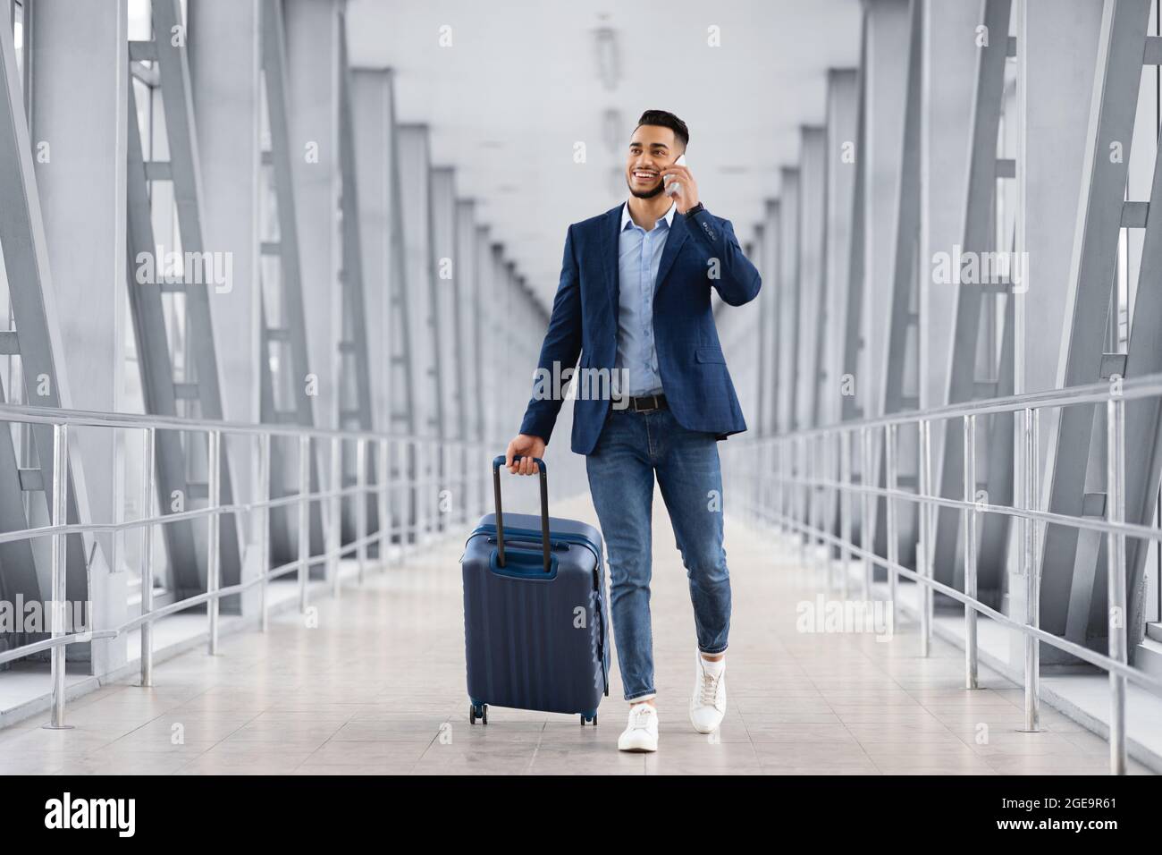 Hübscher Arabischer Mann, Der Mit Dem Koffer Im Flughafen Läuft Und Auf Dem  Handy Spricht Stockfotografie - Alamy