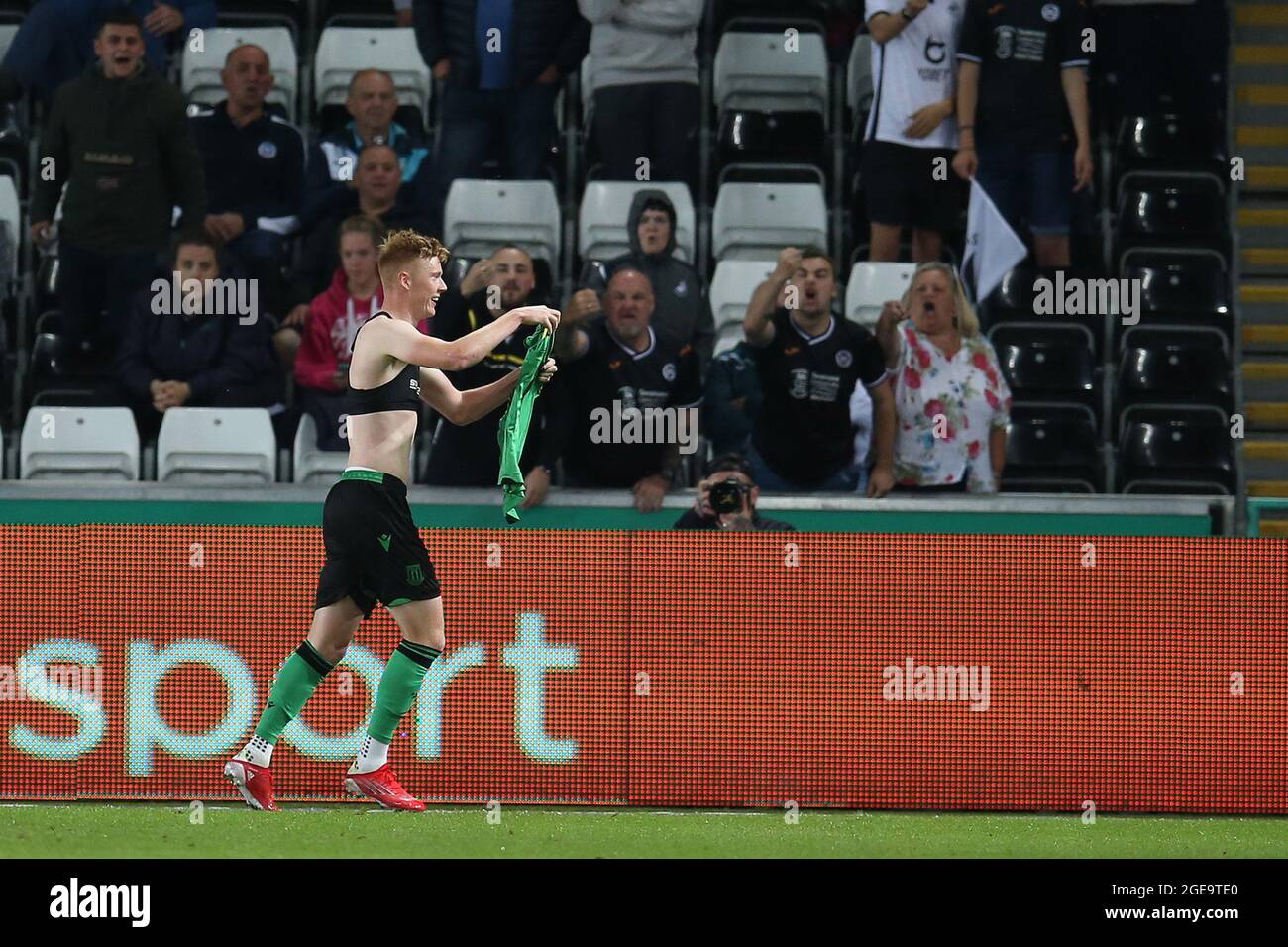 Swansea, Großbritannien. August 2021. Sam Clucas aus Stoke City zieht sein Hemd vor den Fans der Stadt Swansea aus, als er feiert, nachdem er Stoke's 2. Tor erzielt hat. EFL Skybet Championship match, Swansea City gegen Stoke City im Swansea.com Stadium in Swansea am Dienstag, den 17. August 2021. Dieses Bild darf nur für redaktionelle Zwecke verwendet werden. Nur zur redaktionellen Verwendung, Lizenz für kommerzielle Nutzung erforderlich. Keine Verwendung in Wetten, Spiele oder einem einzigen Club / Liga / Spieler Publikationen. PIC von Andrew Orchard / Andrew Orchard Sport Fotografie / Alamy Live News Kredit: Andrew Orchard Sport Fotografie / Alamy Live News Stockfoto