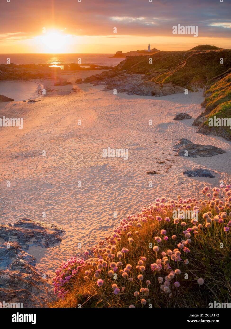 Sonnenuntergang am Sandstrand mit Blick auf den Leuchtturm von Godrevy. Stockfoto