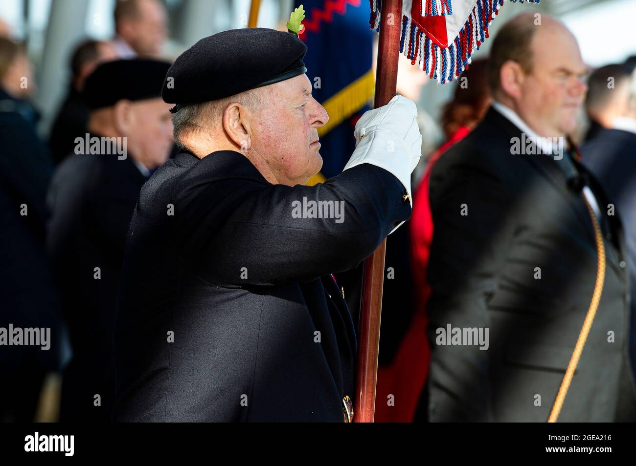 Ein Flaggenträger eines Militärveterans wird am Gedenktag mit der Unionsflagge zur Kenntnis gebracht. Stockfoto