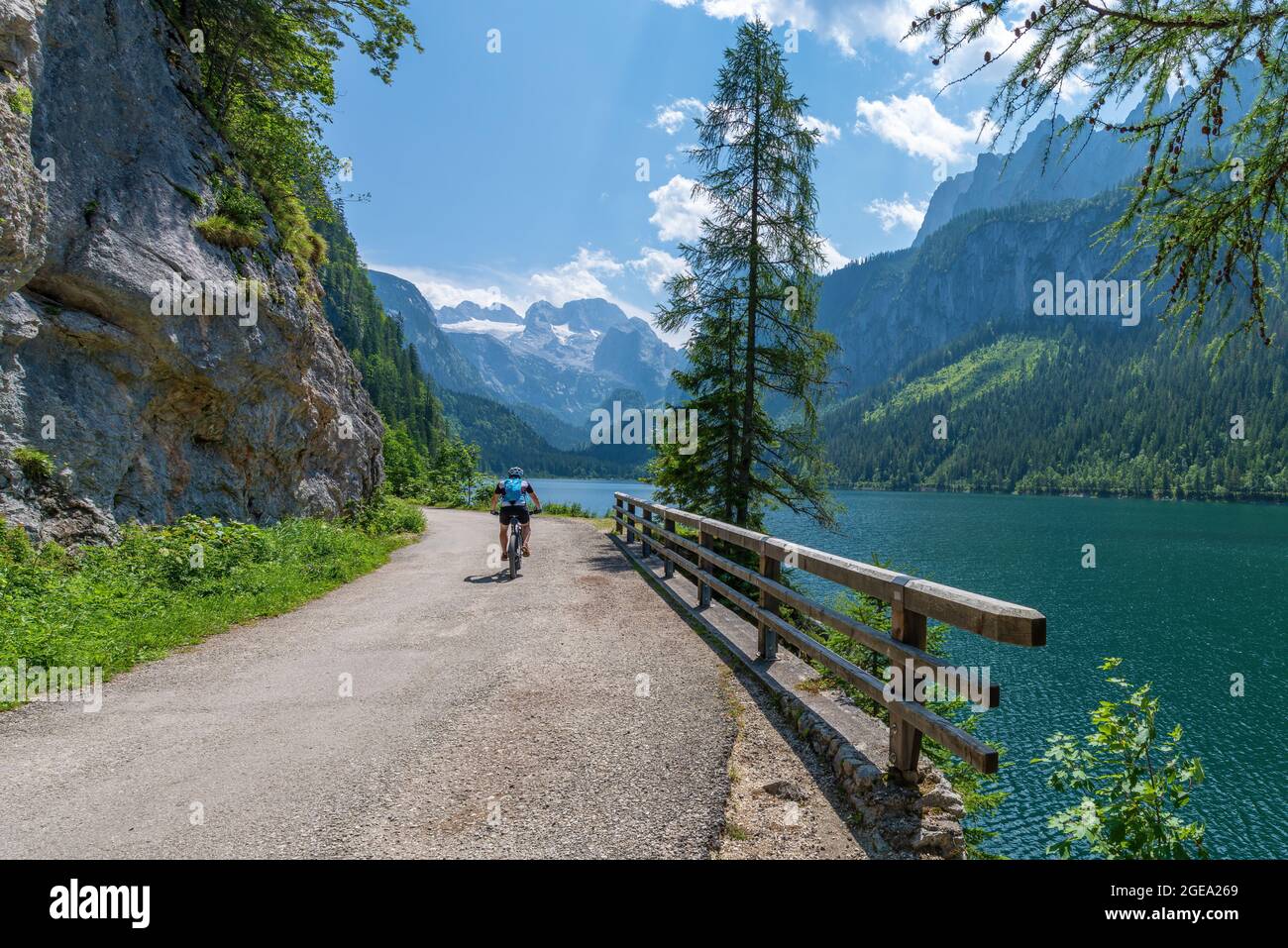 Gosausee, Österreich; 31. Juli 2021 - EINE Person auf dem Mountainbike am Gosausee, einem schönen See mit Bergen im Salzkammergut, Österreich. Stockfoto