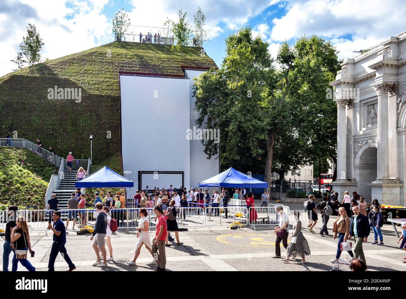 LONDONER MARMORBOGENHÜGEL MENSCHEN WARTEN DARAUF, DIE TREPPE NACH OBEN ZU STEIGEN UND ANDERE, DIE VORBEIKOMMEN Stockfoto