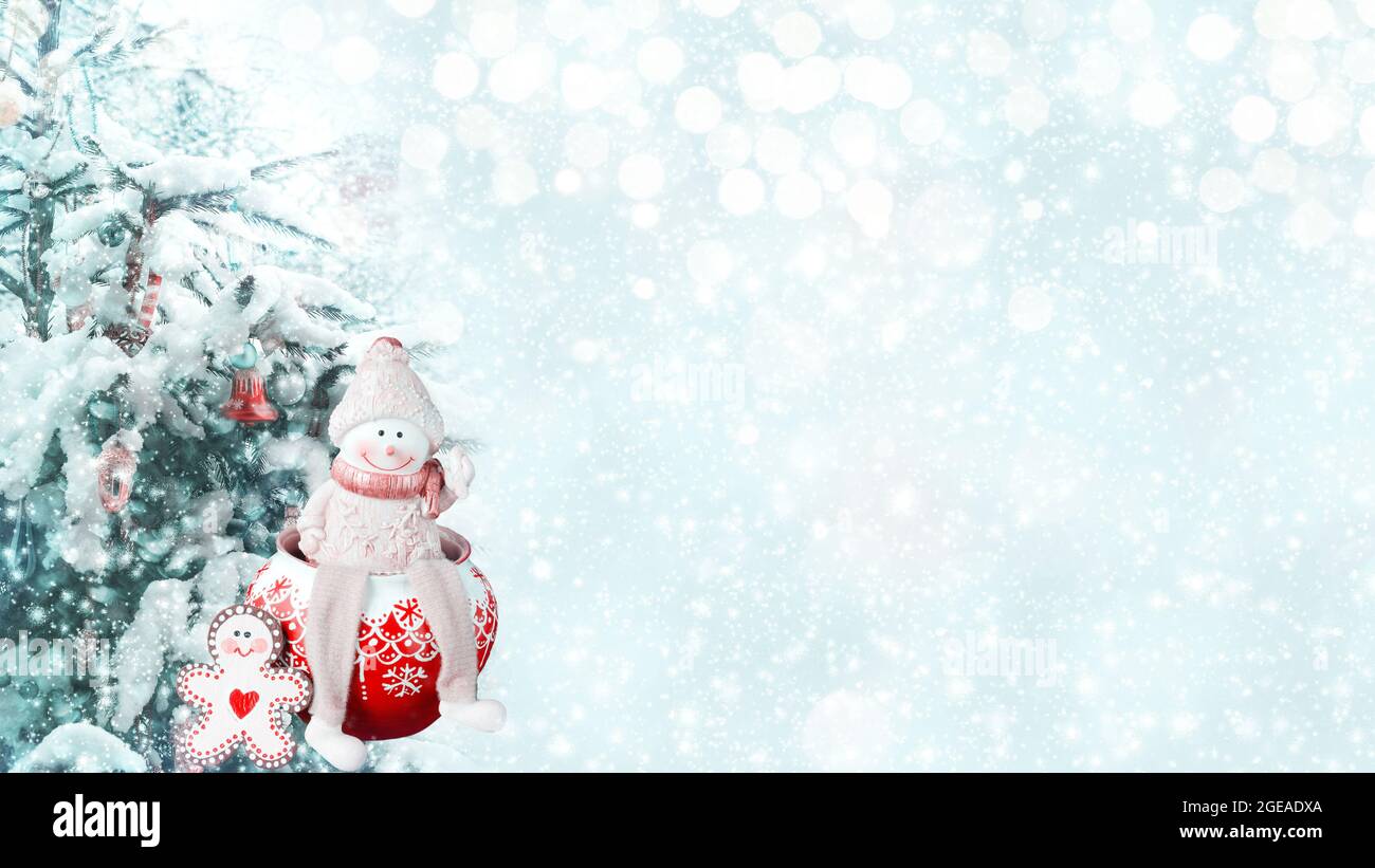 Weihnachtlicher unfokussierter Hintergrund mit einem verzierten Weihnachtsbaum und einem lustigen Schneemann. Winterkunst des neuen Jahres Design Stockfoto