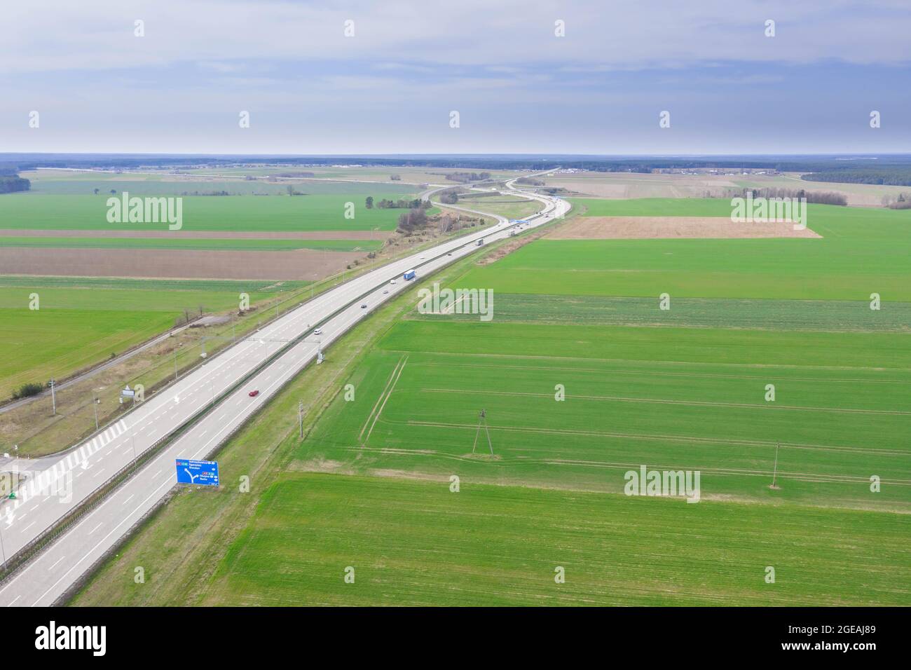 Die Autobahn von einer großen Höhe aus gesehen. Zwei graue Betonstraßen. An den Seiten befinden sich Felder. Foto von einer fliegenden Drohne. Stockfoto
