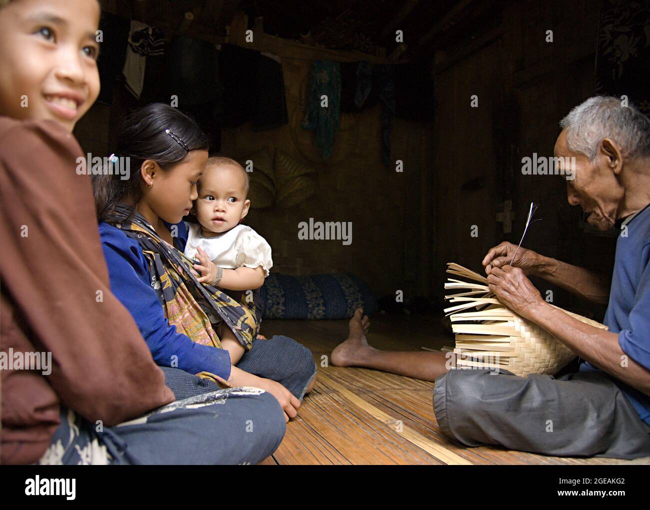 Eine Familie von Baduy sitzt in ihrem Haus zusammen. Baduy ist ein Stamm in Banten, Indonesien. Sie pflegen ihren traditionellen Lebensstil bis heute. Stockfoto