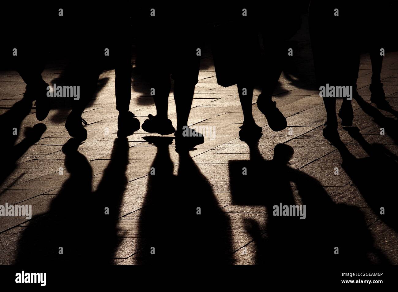 Schwarze Schatten und Silhouetten von Menschen auf der Straße. Menschenmenge, die auf dem Bürgersteig hinuntergeht, Konzept von Fußgängern, Kriminalität, Gesellschaft, Bevölkerung Stockfoto