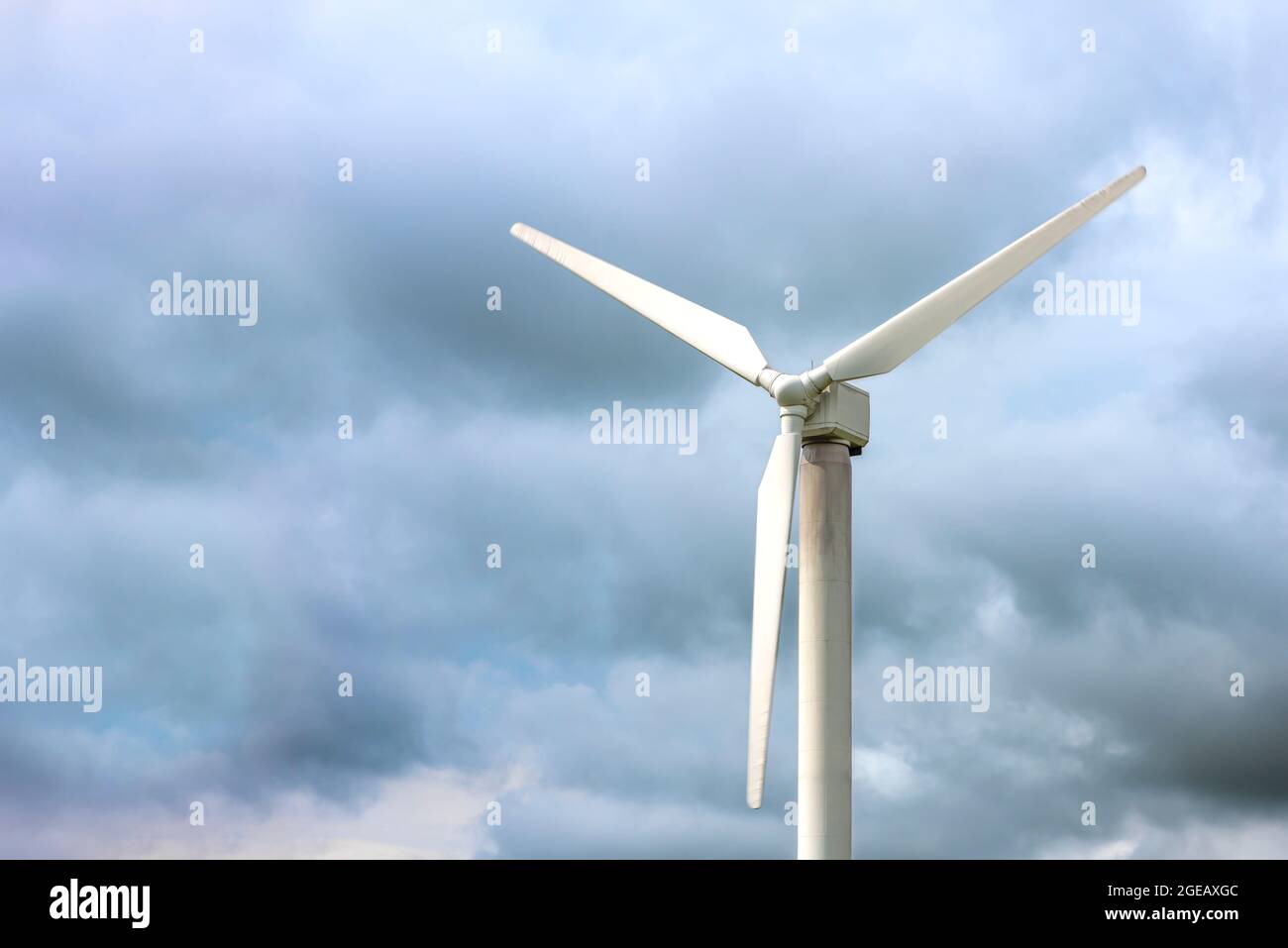 Windmühlen für die Stromerzeugung. Windturbine vor dem Hintergrund eines dunklen düsteren Himmels, windiges Wetter, Ort, um Text einzufügen. Stockfoto