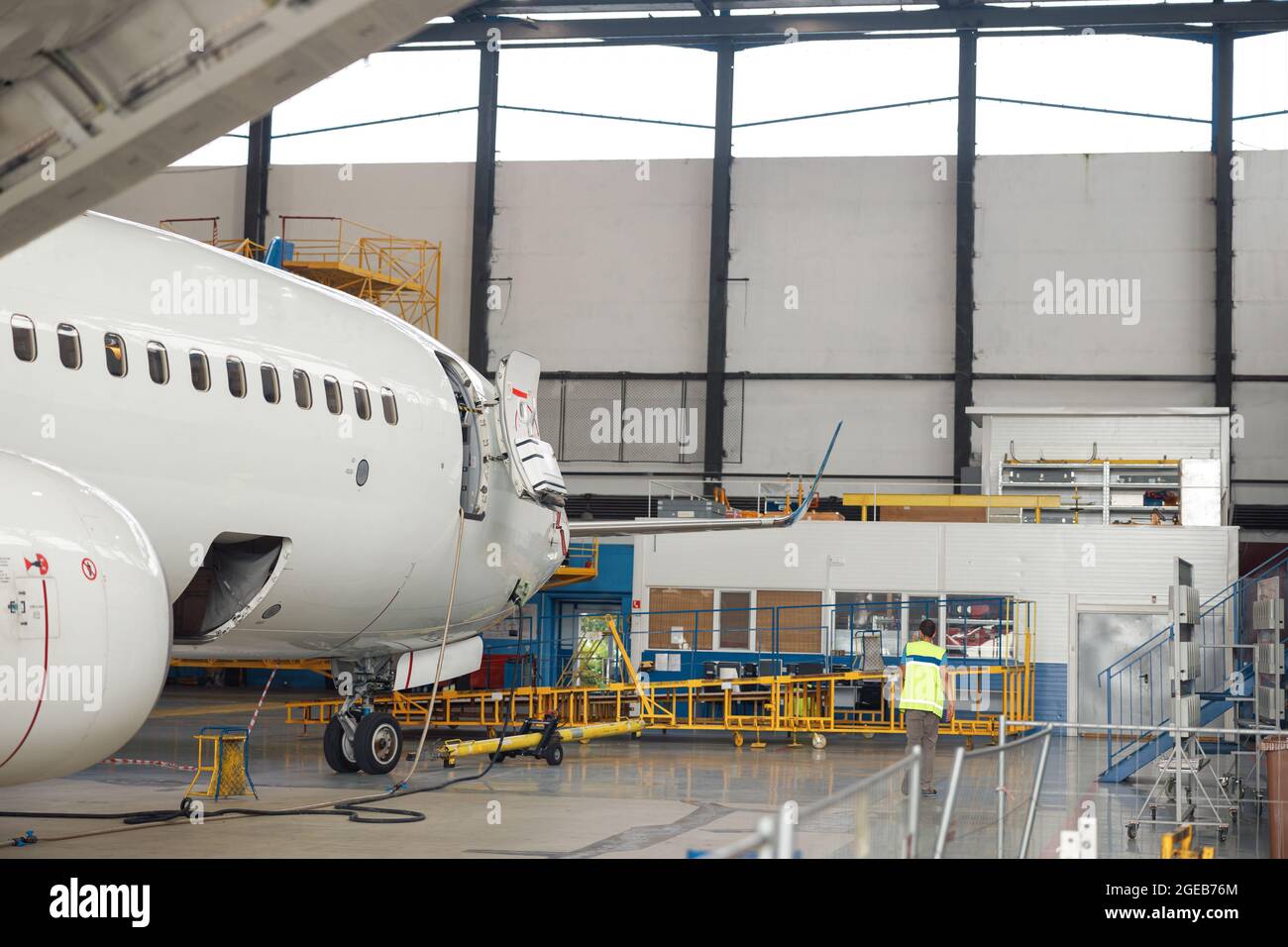 Flugzeug. Passagierflugzeug, das tagsüber in einem Flughafenhangar in Innenräumen stark gewartet wird Stockfoto