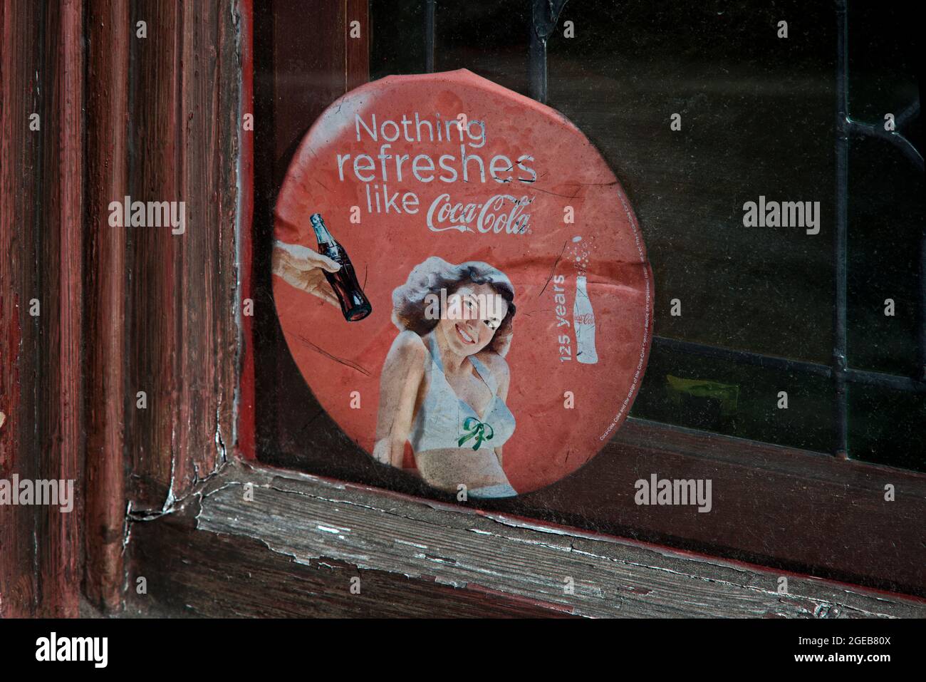 Coca-Cola-Werbespot im Retreo-Stil in einem verwitterten und abgenutzten Fenster. Stockfoto