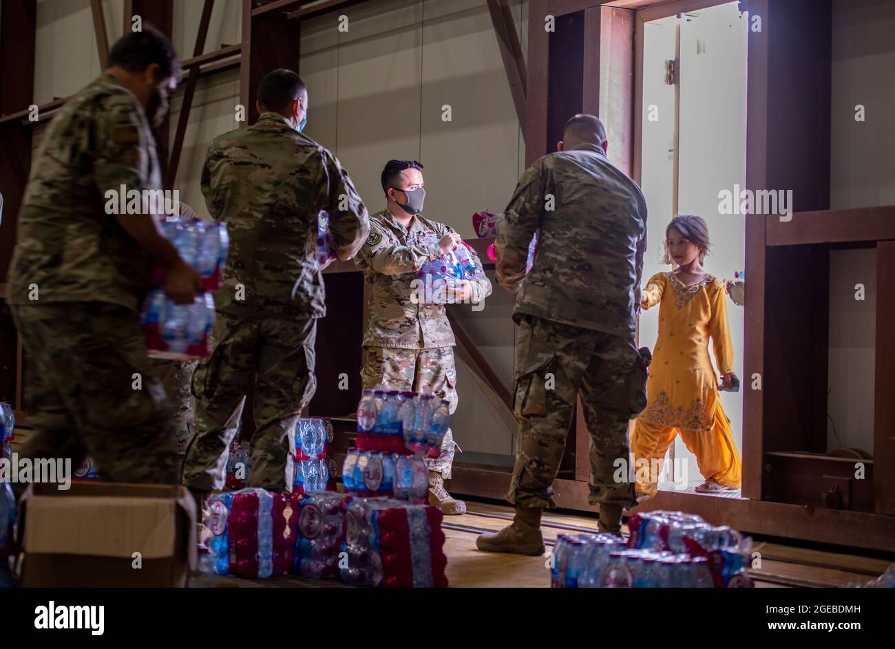 Mitglieder des 379. Air Expeditionary Wings verteilen Wasser an afghanische Bürger im Rahmen der Operation Allies Refuge am 16. August 2021 auf dem Al Udeid Air Base, Katar. Das Verteidigungsministerium hat sich verpflichtet, das US-Außenministerium beim Ausscheiden von US-amerikanischem und alliiertem Zivilpersonal aus Afghanistan zu unterstützen und die afghanischen Verbündeten in Sicherheit zu bringen. (USA Luftwaffe Foto von Airman 1st Class Kylie Barrow) Stockfoto