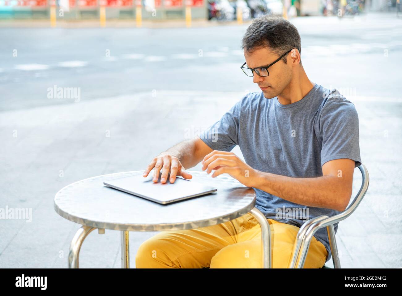 Junger latein, der seinen Computer draußen öffnete. Stockfoto