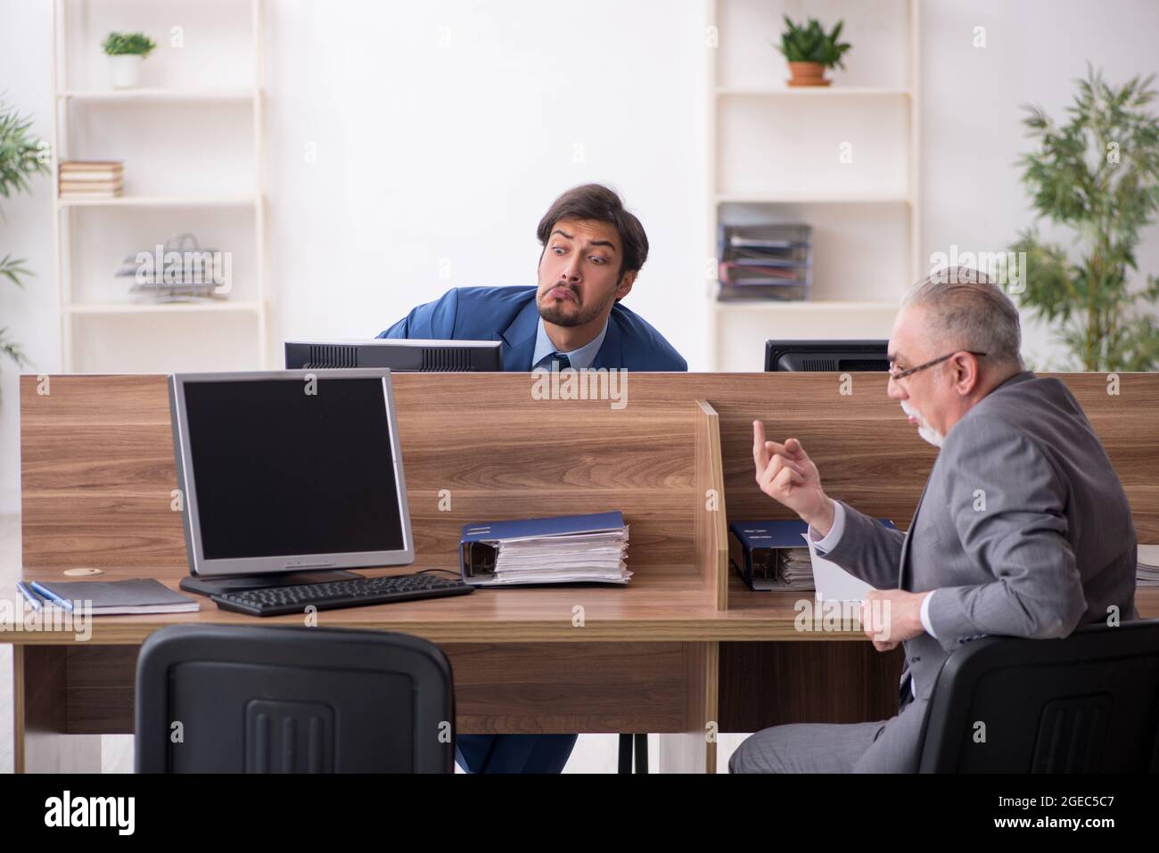 Zwei männliche Mitarbeiter, die am Arbeitsplatz arbeiten Stockfoto