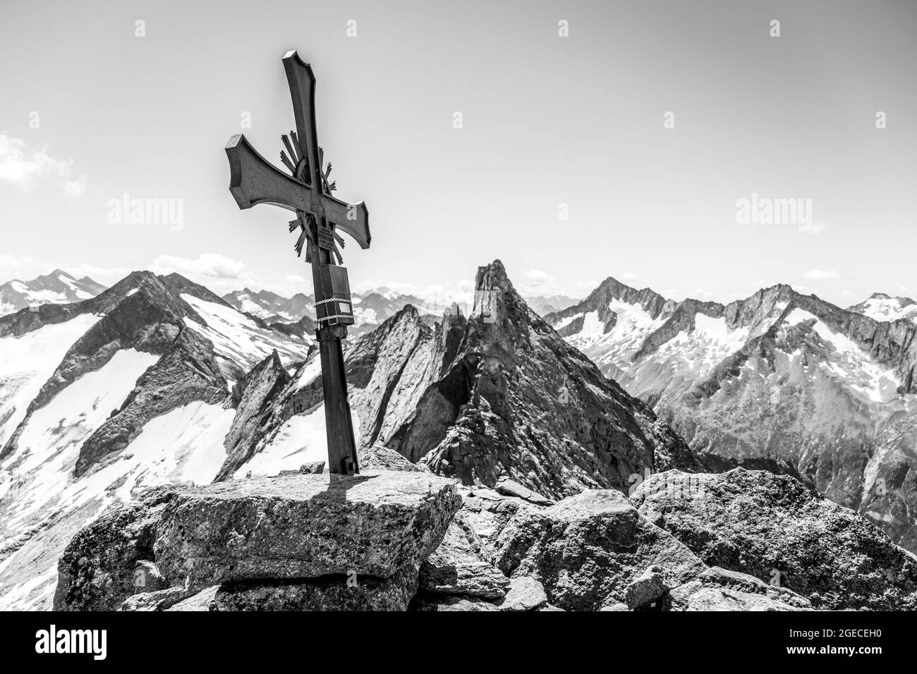 Gipfelkreuz aus Metall auf der Richterspitze, Zillertaler Alpen, Österreich. Schwarzweiß-Bild. Stockfoto