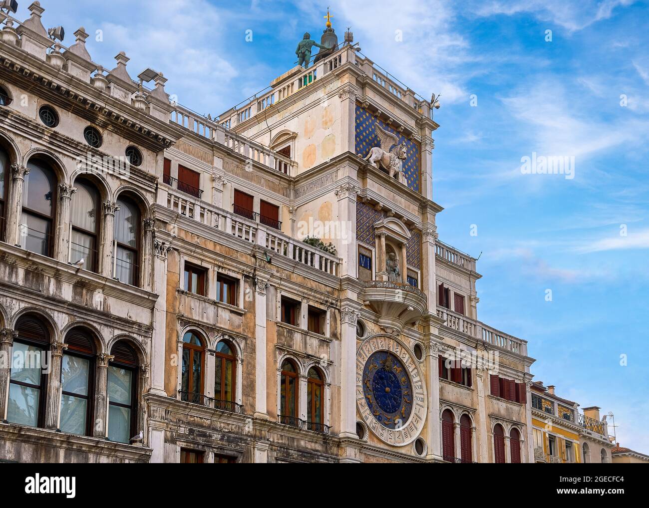 Berühmter Torre dell'Orologio oder Uhrturm auf dem Markusplatz in Venedig, Italien. Mauren, Löwe, Jungfrau Maria Skulpturen, mittelalterliche Uhr, blauer Himmel, Wolken. Stockfoto